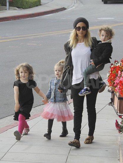 Moderna mamica Nicole Richie obkrožena s kodrastimi otročički